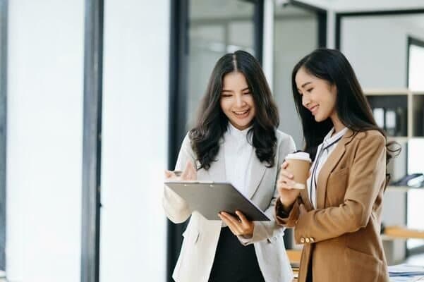 Two Asian professionals reviewing mobility paperwork