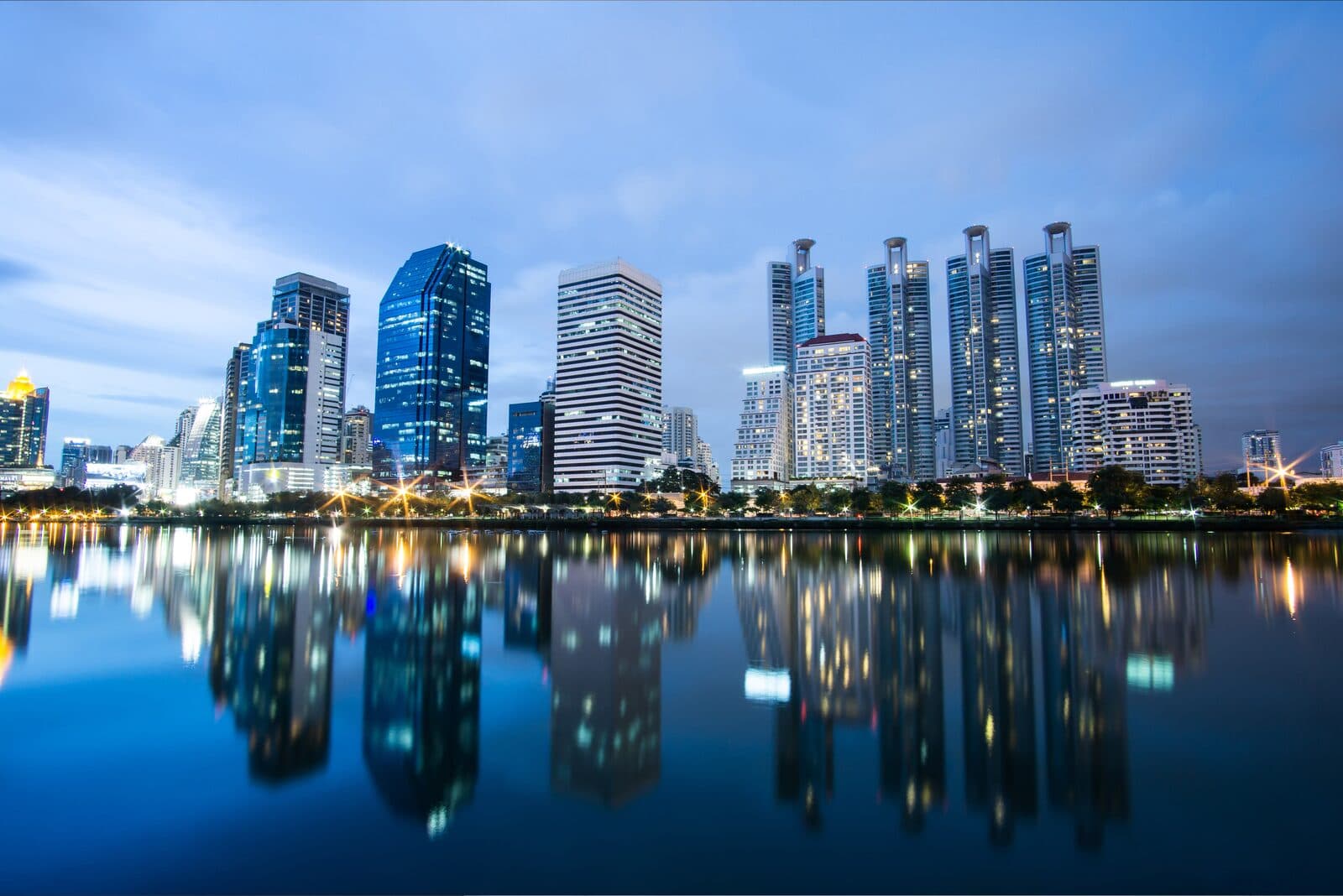 Bangkok business district skyline at night reflected on water