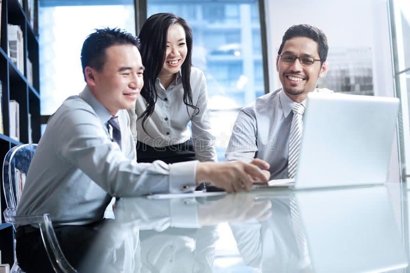 Asian HR team collaborating at a laptop